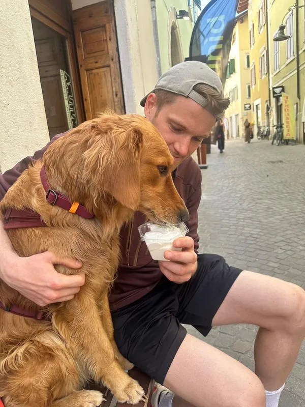Niklas holding Nugget, who is licking a cup of gelato