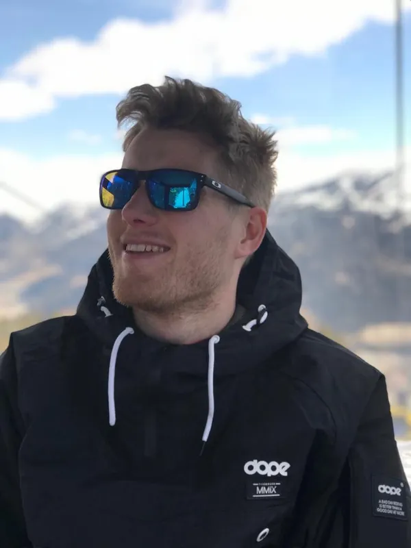 Niklas in sunglasses in front of snowy mountains